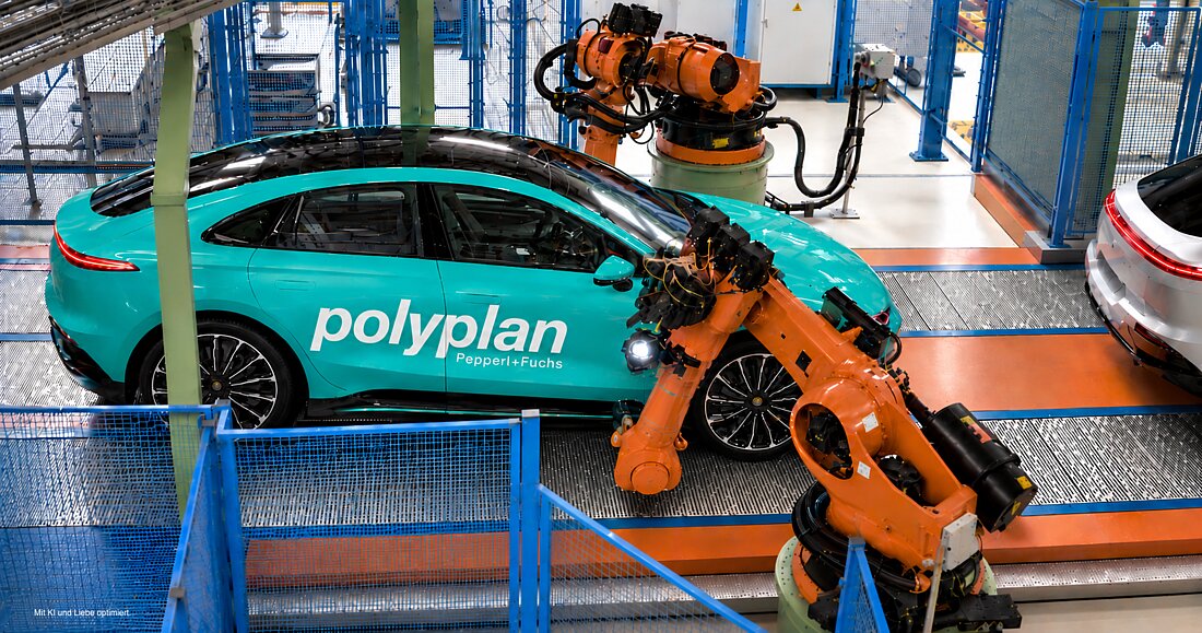 一辆青绿色的 Polyplan 汽车位于自动化生产设施中，周围有橙色工业机器人。